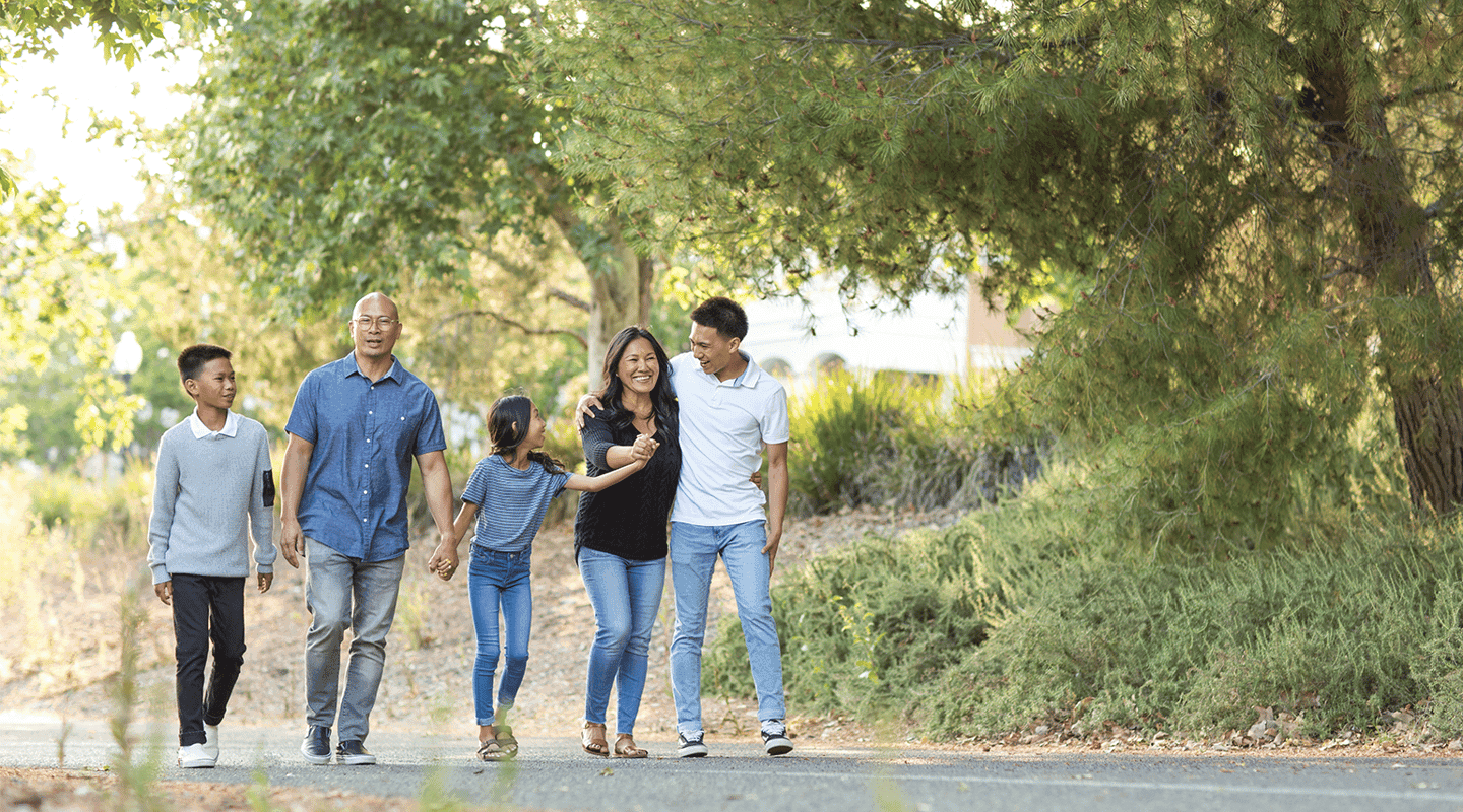 family walking along trail outside on gravel path