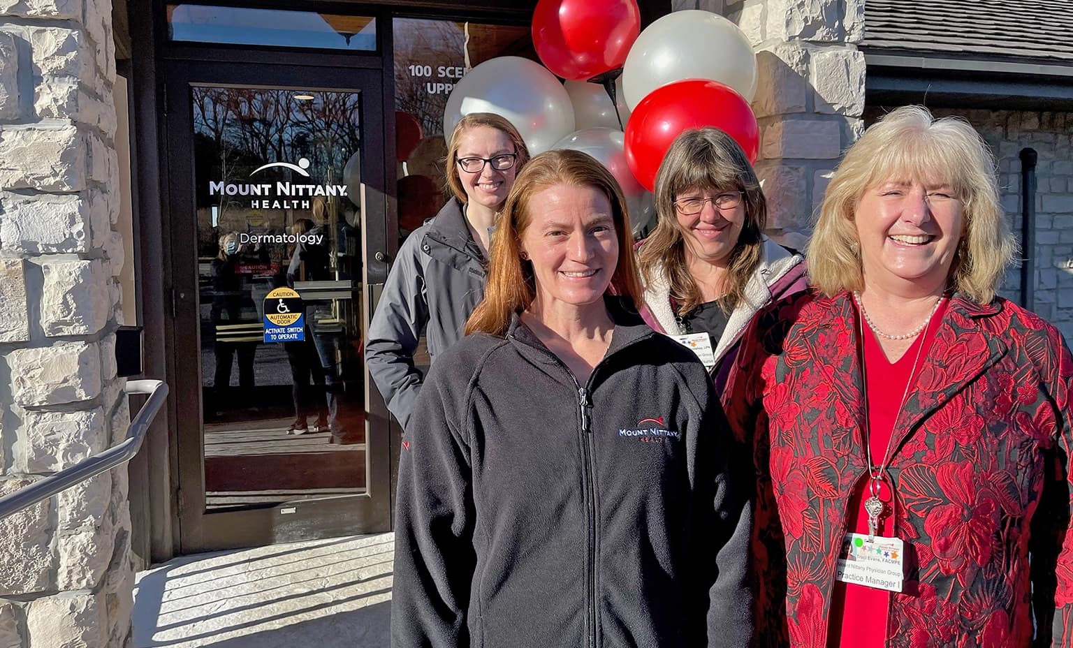 Members of Mount Nittany Health Dermatology stand in front of the door of the new location