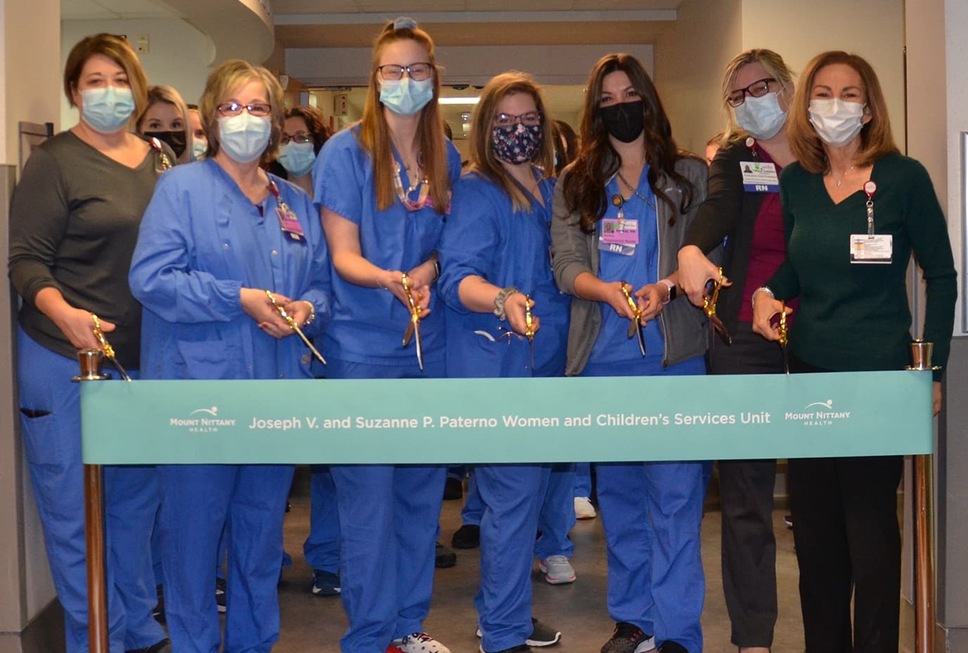 Women and children's members prepare to cut the ribbon to open the new unit