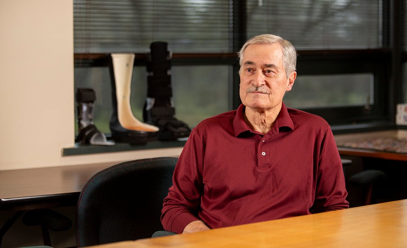 Bill Chyle sits in front of orthotic equipment