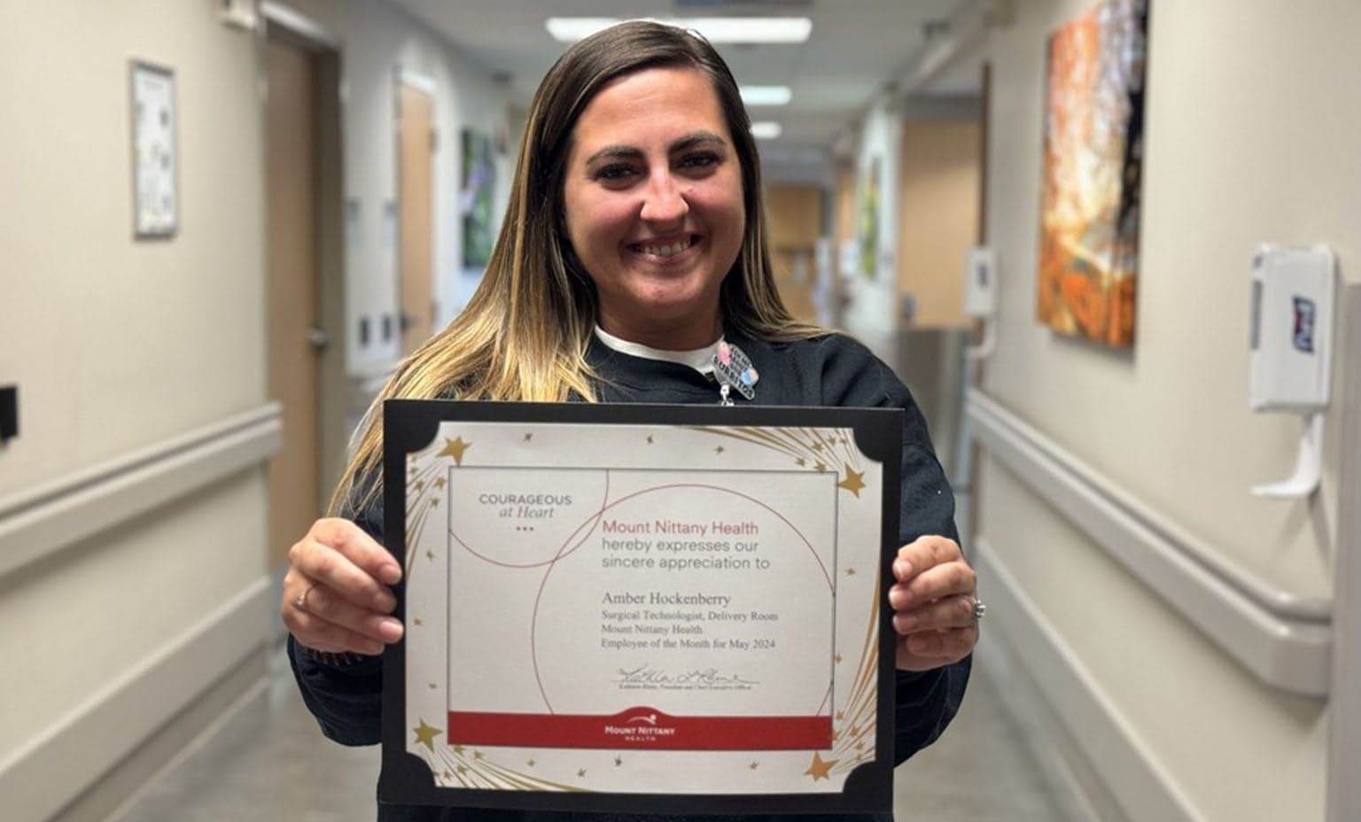 Amber Hockenberry holds her Employee of the Month certificate