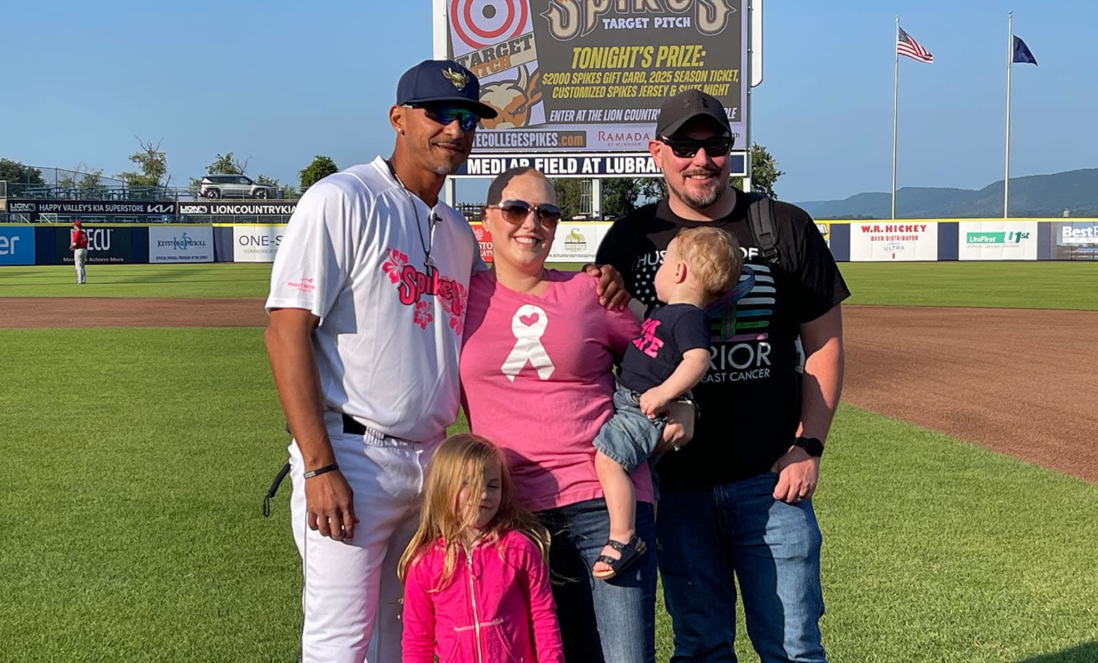 Pam Crants poses with her family and Spikes players during Paint the Park Pink Event