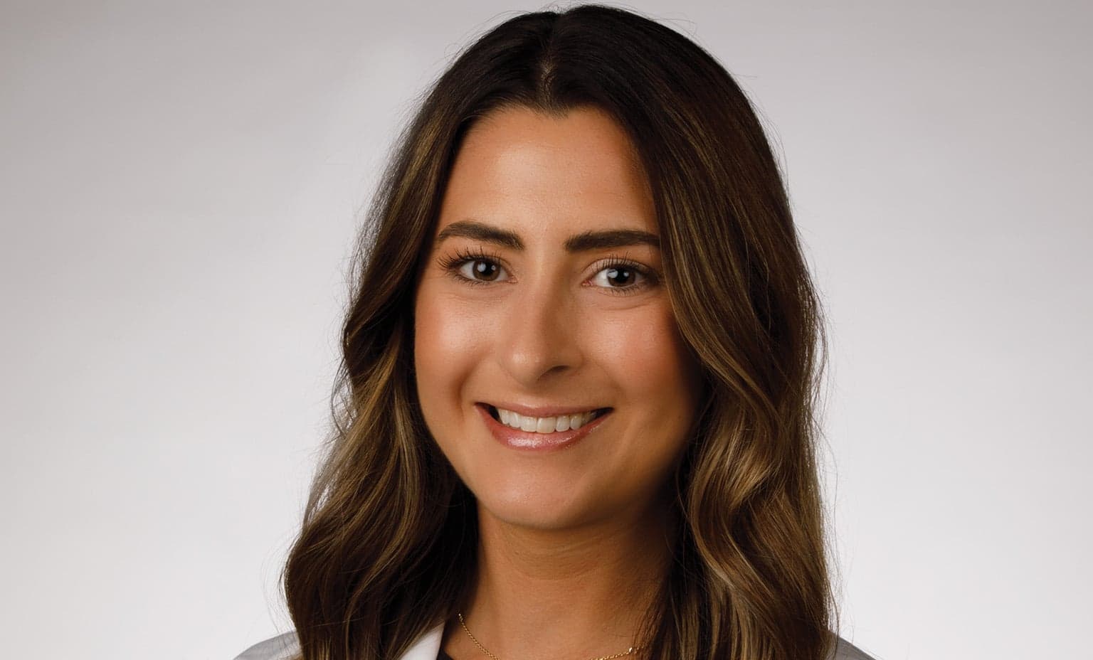 Lauren Sullivan Audiologist smiles for a photo in her white coat