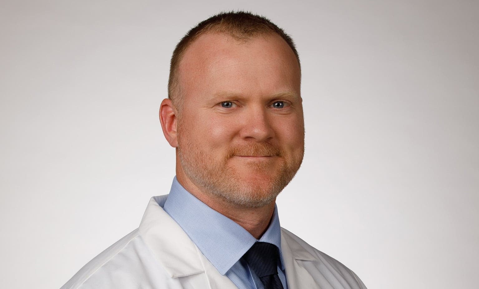 Dr. Ian Yarger smiles while wearing his whitecoat