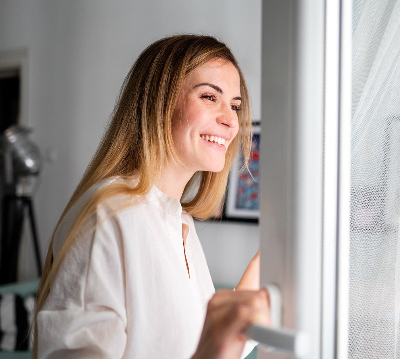 Plastic surgery patient smiles looking out window after healing from treatment