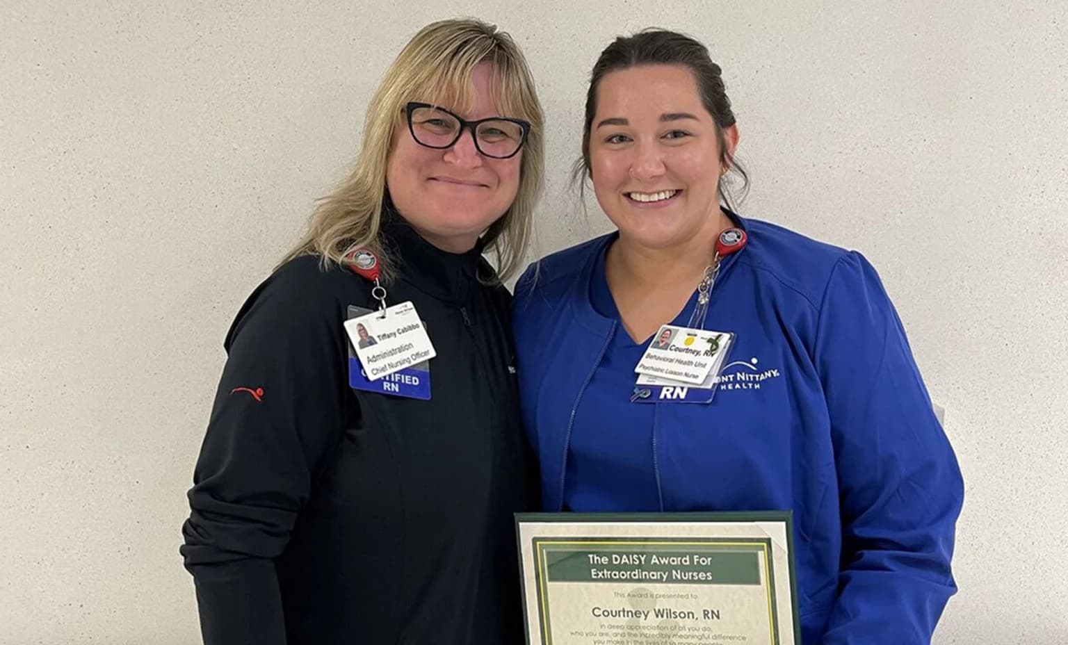Courtney Wilson poses with Tiffany Cabibbo for a photo with her DAISY award certificate