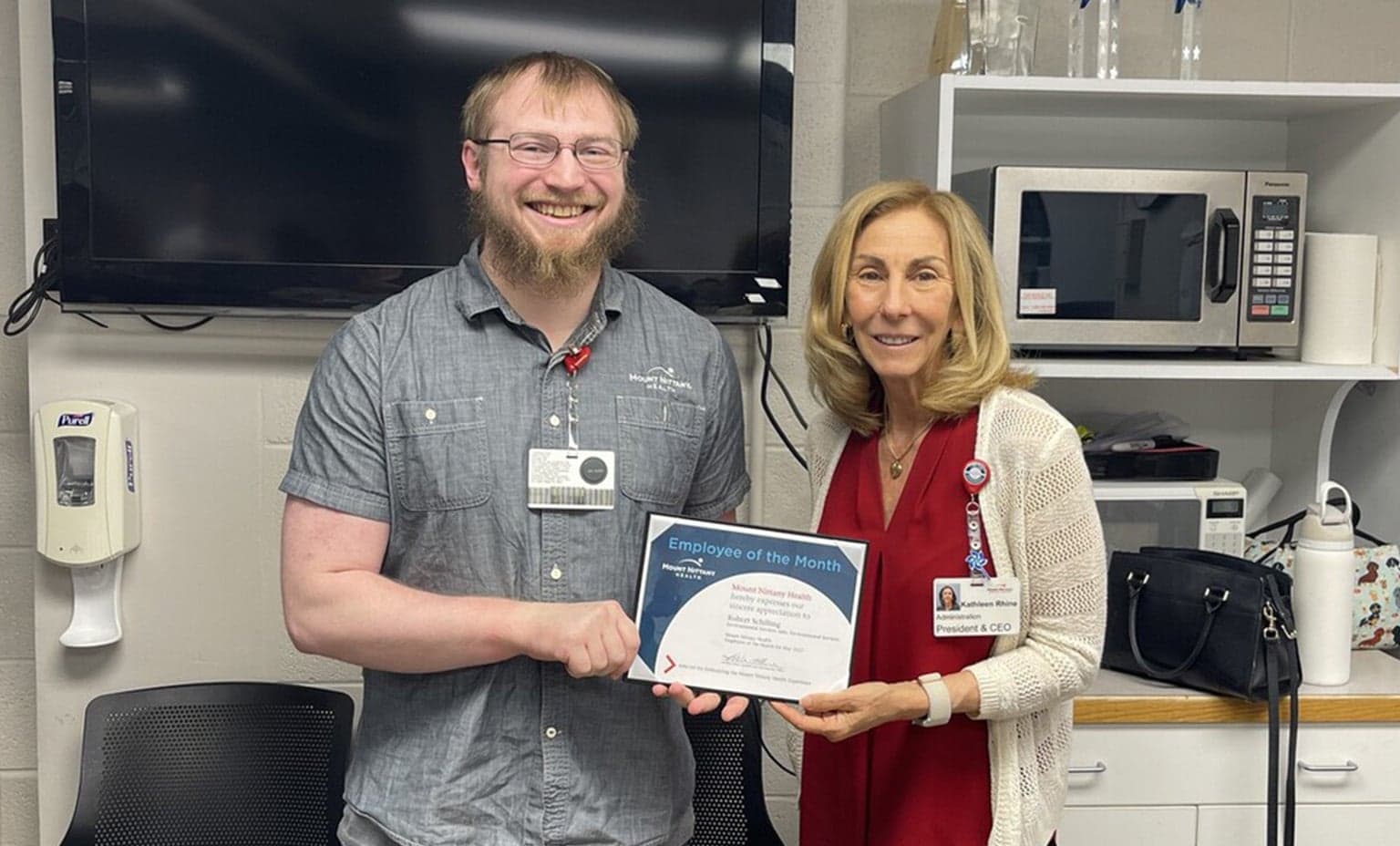 Rob Schilling and Kathleen Rhine hold the employee of the month certificate
