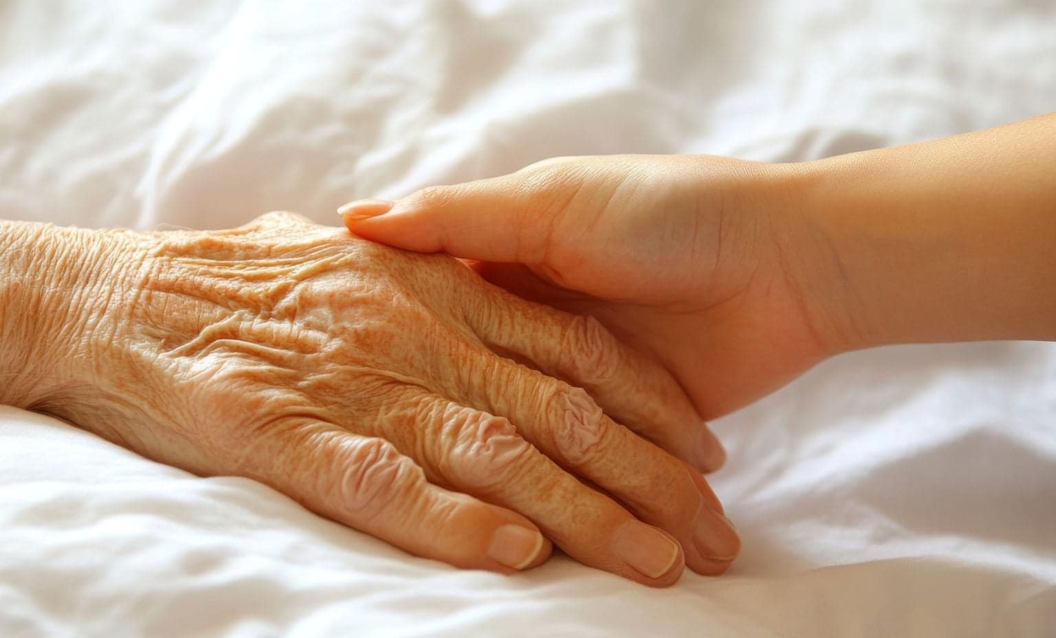 Young hand holding older hand