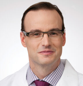 Dr. Frederick Doucette OBGYN poses for a photo in his white coat