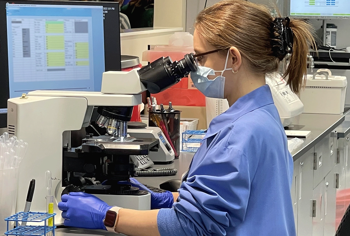 A woman looks into laboratory equipment