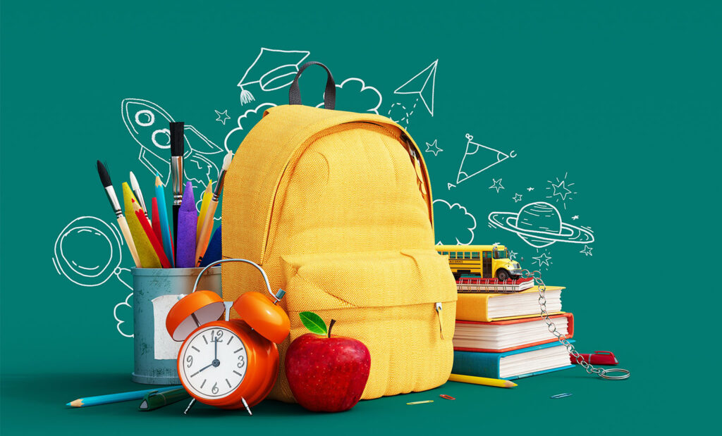 Yellow backpack and school supplies with a dark green background