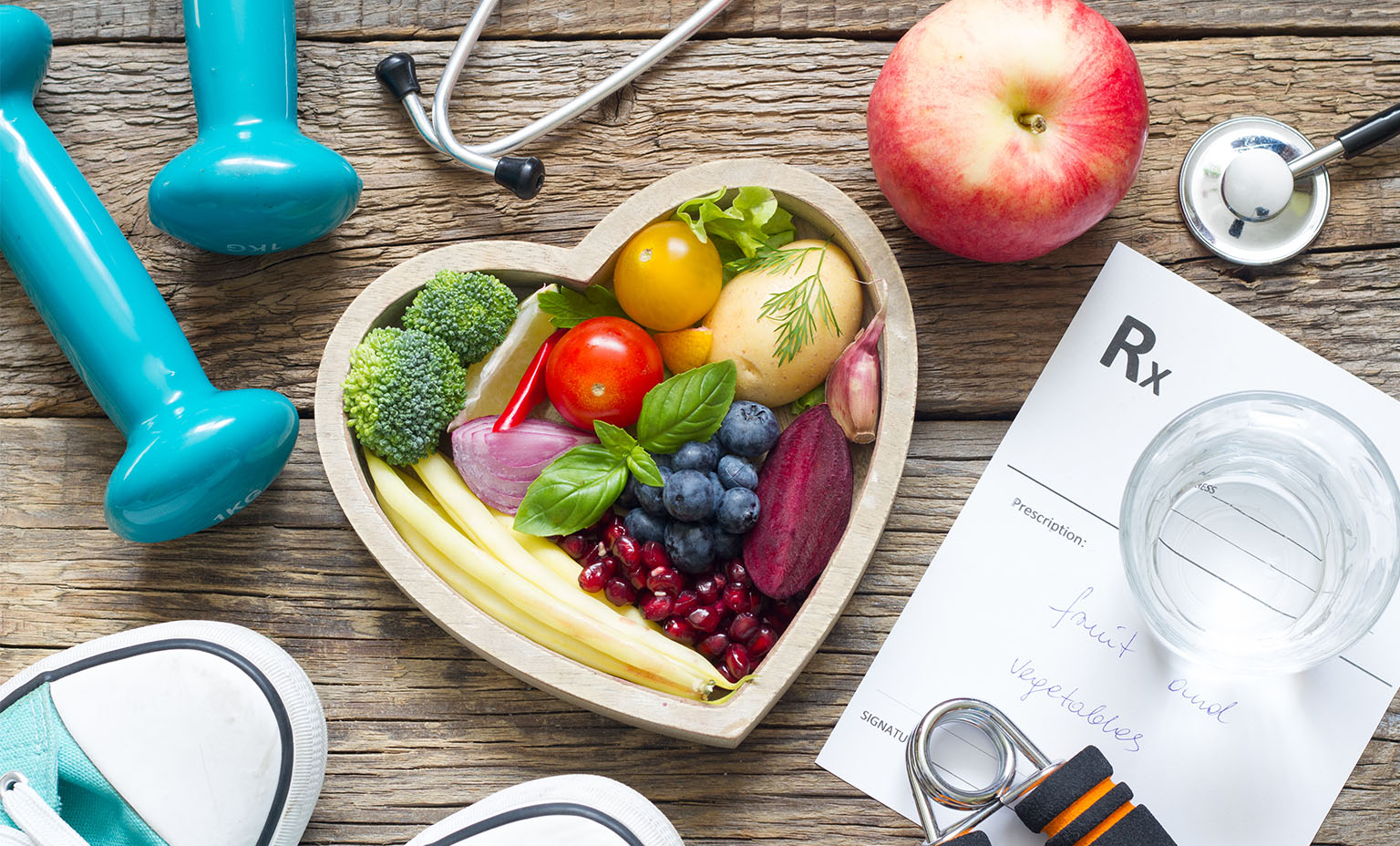 fruit, vegetables, shoes, a prescription pad and a stethoscope lay on a table