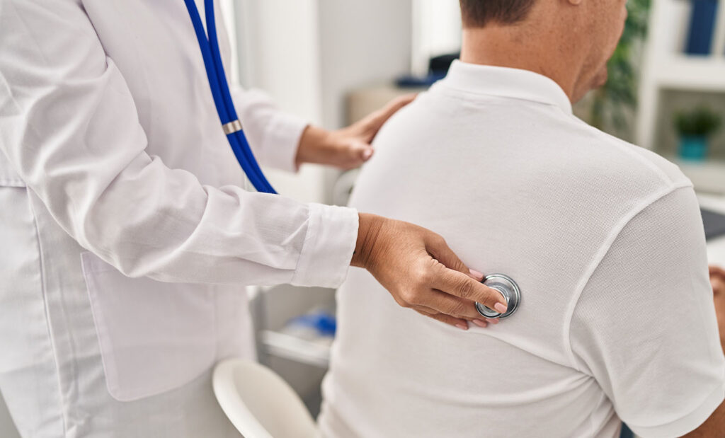 Doctor listens to pulmonary patients lungs during rehab appointment