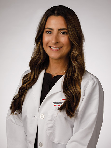 Lauren Sullivan Audiologist smiles for a photo in her white coat