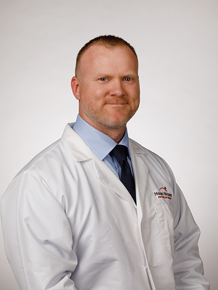 Dr. Ian Yarger smiles while wearing his whitecoat