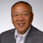 Dr. David Han, Vascular Surgeon smiles for a photo in front of a white backdrop
