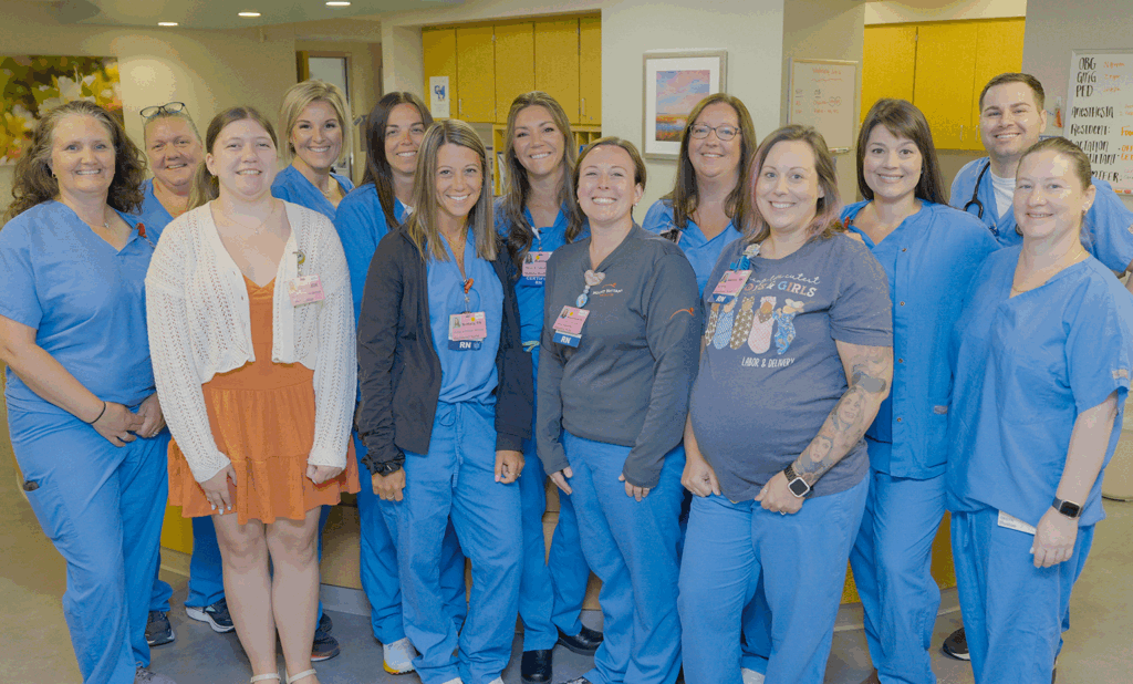 medical professional in scrubs stand and smile for group picture