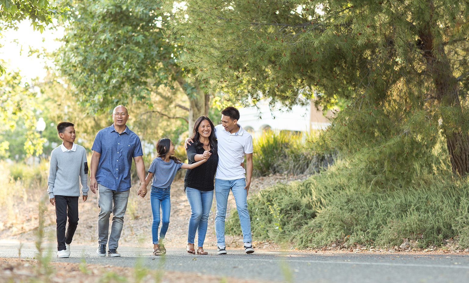 family walking along trail outside on gravel path