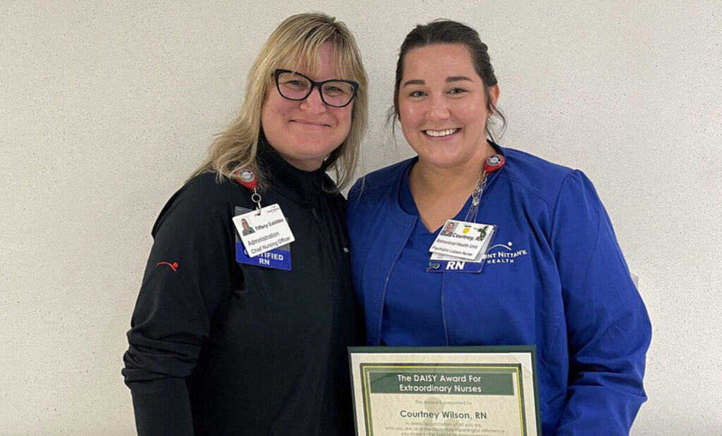 Courtney Wilson poses with Tiffany Cabibbo for a photo with her DAISY award certificate