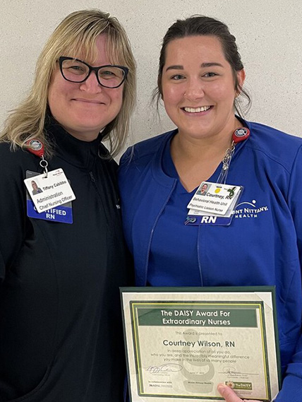 Courtney Wilson poses with Tiffany Cabibbo for a photo with her DAISY award certificate