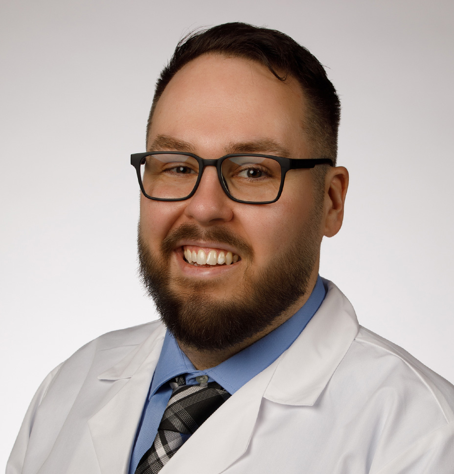 Michael Figart DO smiles while wearing his white coat for a professional headshot photo