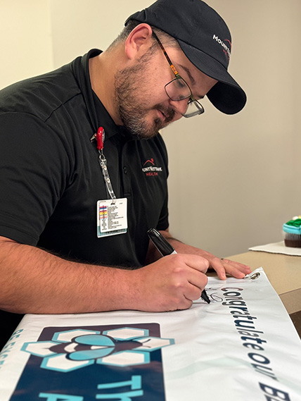 Lee Fulton, Culinary Services signs the BEE award banner