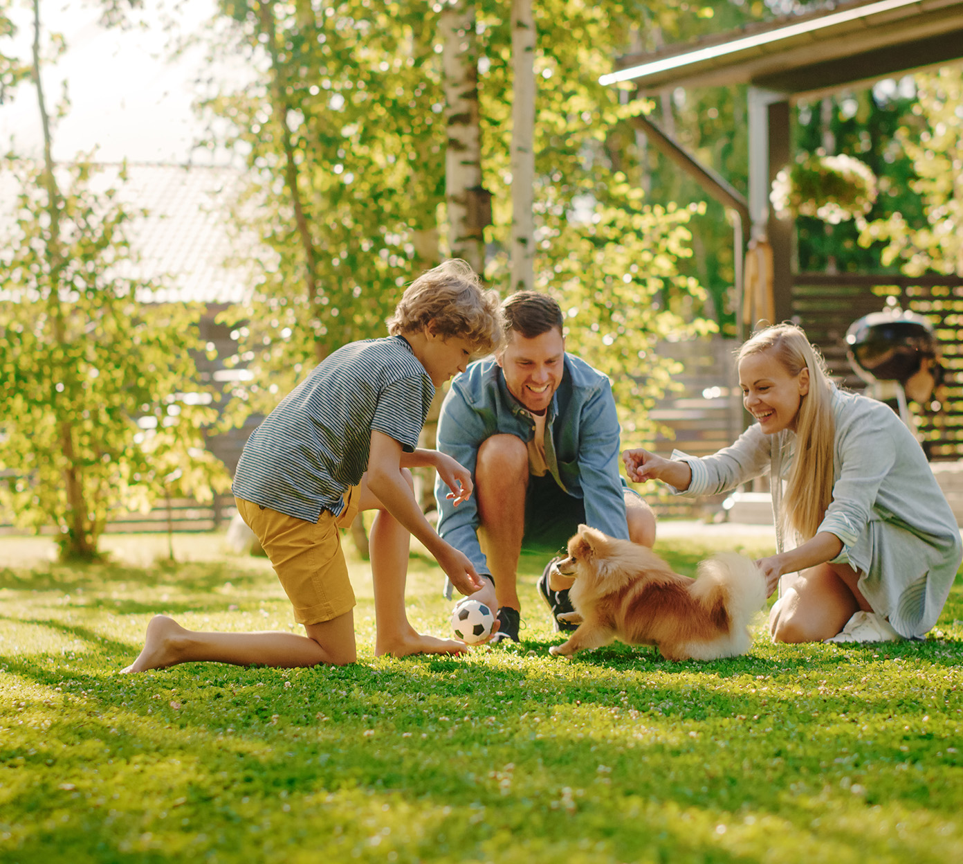 A family plays outside in their back yard with a puppy